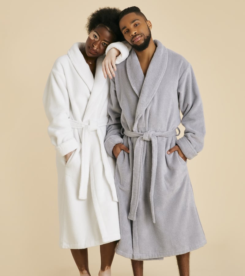 Man and woman wearing our Super-Plush robes in White and Smoke.